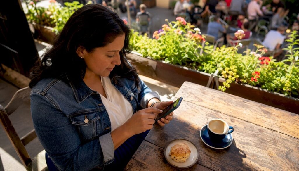 Woman verifying identity on smartphone in café